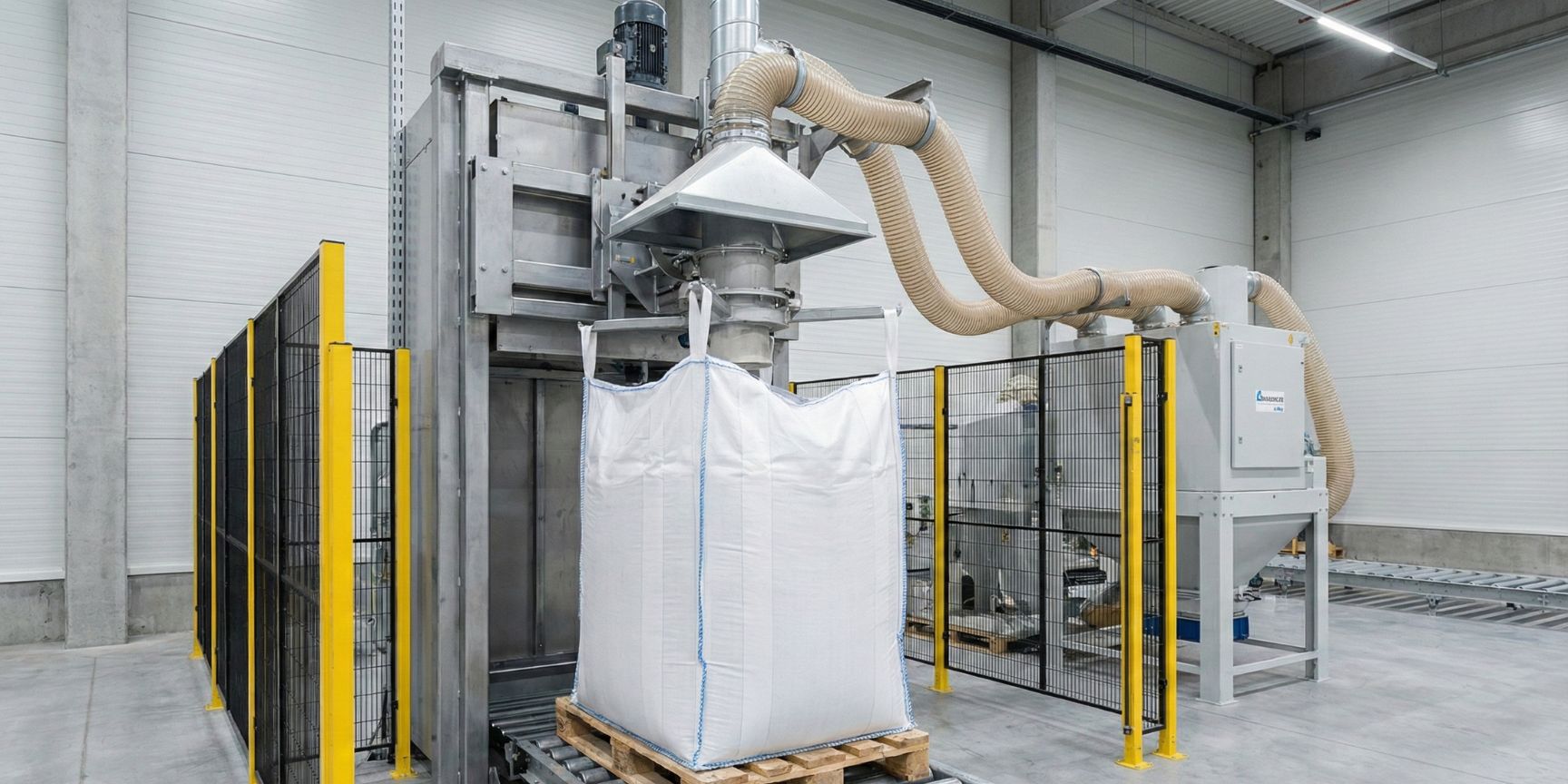 Automatische Big-Bag-Abfüllanlage in einer Logistikhalle. Ein weißer Q-Bag (formstabiler Big Bag) wird auf einer Palette befüllt, während eine Absauganlage für Staubschutz sorgt.